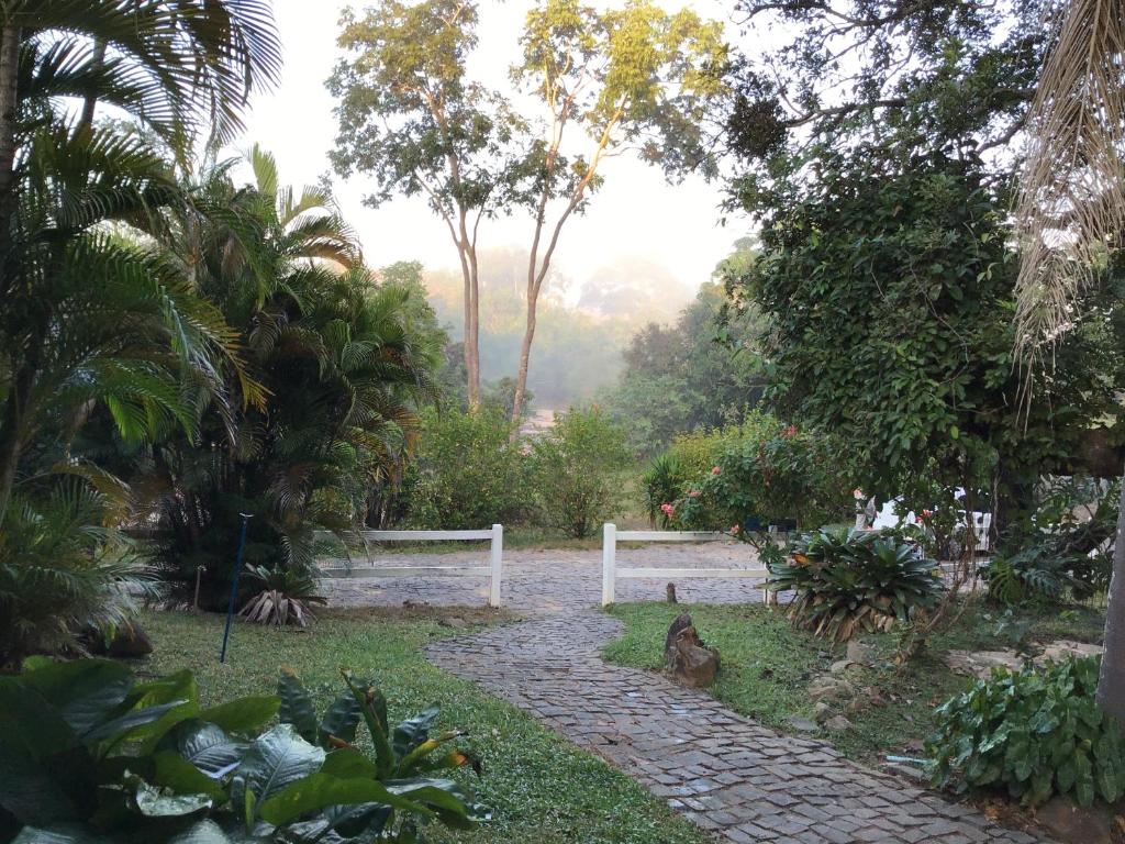a bird sitting on a path in a garden at Hotel Fazenda Tia Dora in Três Marias