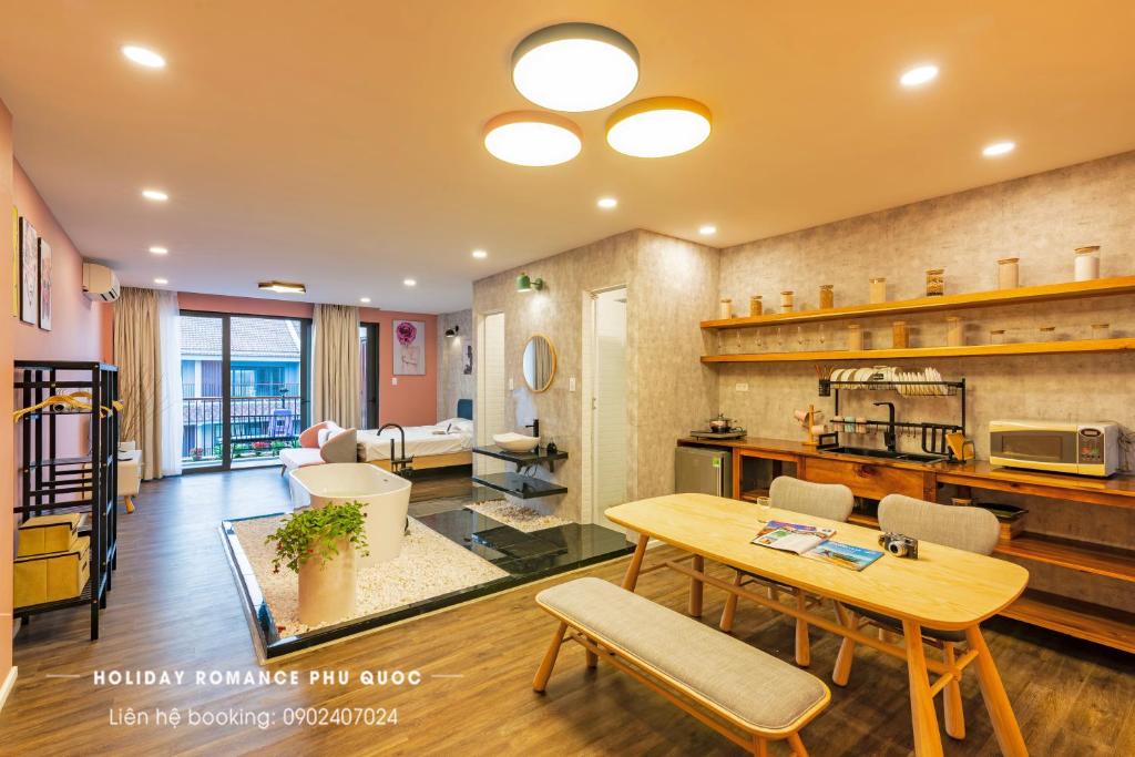 ein Wohnzimmer mit einem Tisch und einer Küche in der Unterkunft Minimalist & Modern Apartment III in Phu Quoc