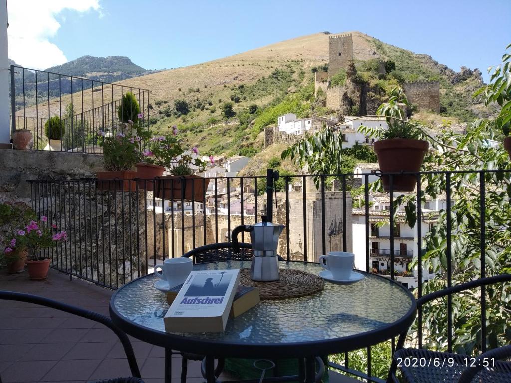 einen Tisch mit einem Buch auf dem Balkon in der Unterkunft Alojamientos Peña del Rey in Cazorla