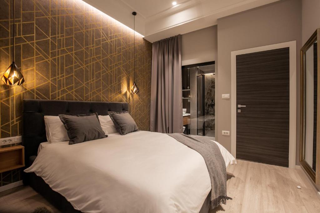 ein Schlafzimmer mit einem großen Bett und einer Wand in der Unterkunft Harbour Residence Rooms in Rijeka