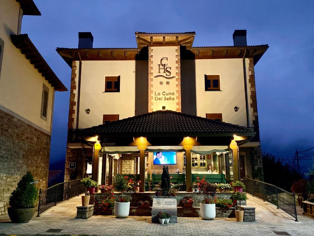 un edificio con un reloj en la parte delantera en Hotel La Cuna del Sella en Oseja de Sajambre