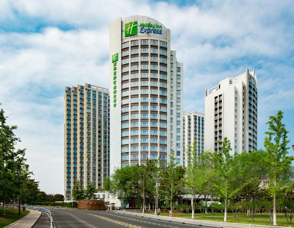 Holiday Inn Express Weihai Hi-Tech Zone, an IHG Hotel في ويهاي: مبنيان طويلان عليهما لافتة