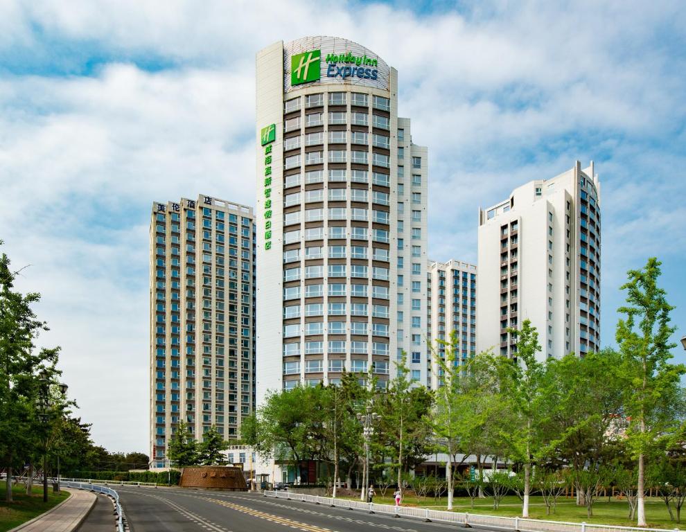 dos edificios altos con un cartel encima en Holiday Inn Express Weihai Hi-Tech Zone, an IHG Hotel, en Weihai