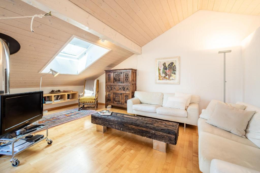 uma sala de estar com um sofá e uma televisão em Casa Alva - FLIMS em Flims