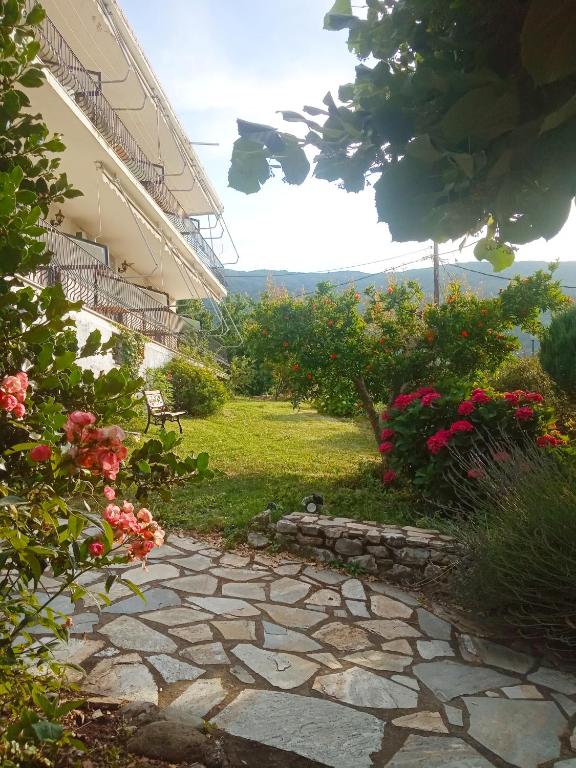a stone walkway next to a building with flowers at Kandilari Apartments in Kokkino Nero