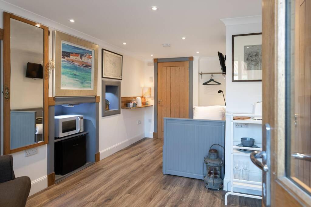 a small room with a kitchen with a microwave at Old Rope Store in Pittenweem