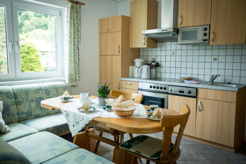 una cucina con tavolo e una cucina con divano di Appartements Caroline a Ossiach