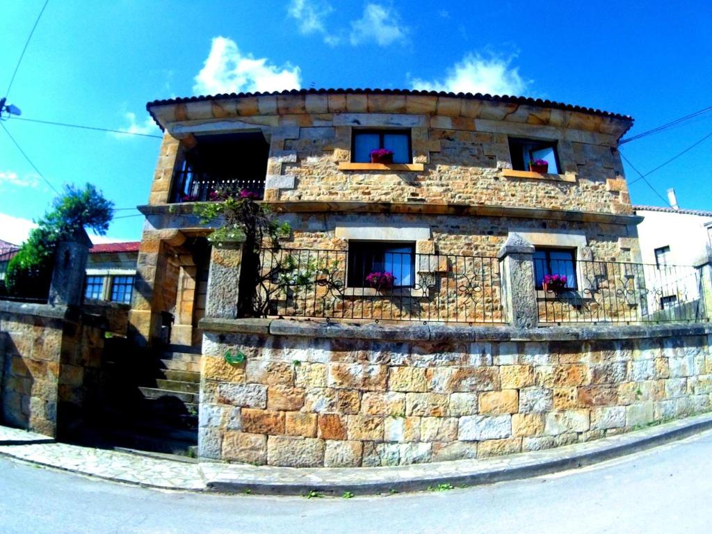 - un bâtiment en pierre avec deux fenêtres et un balcon dans l'établissement Casa Los Maestros, à Bostronizo