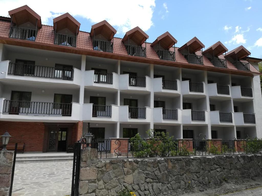 un gran edificio blanco con balcones. en Hotel Iveria, en Abastumani