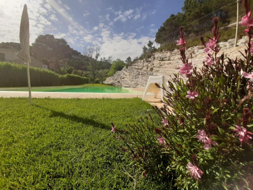 - une vue sur une cour avec une piscine et des fleurs dans l'établissement Locanda Angelica, à Giarratana