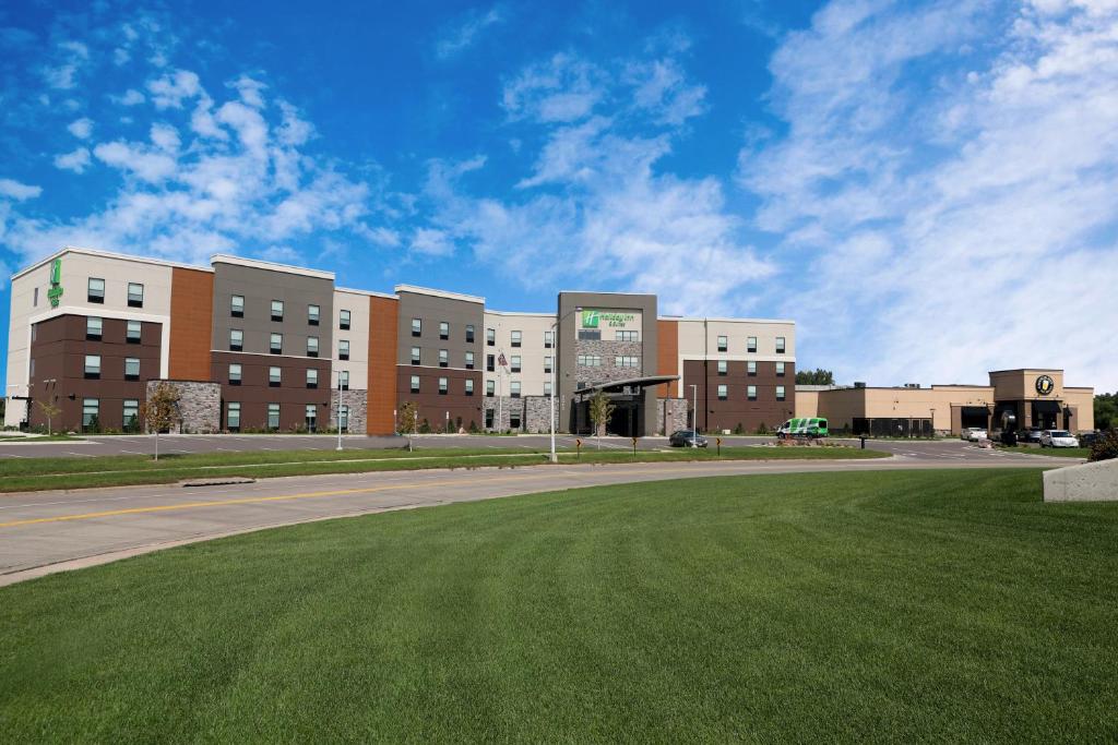 a large building with a grass field in front of it at Holiday Inn & Suites Sioux Falls - Airport, an IHG Hotel in Sioux Falls