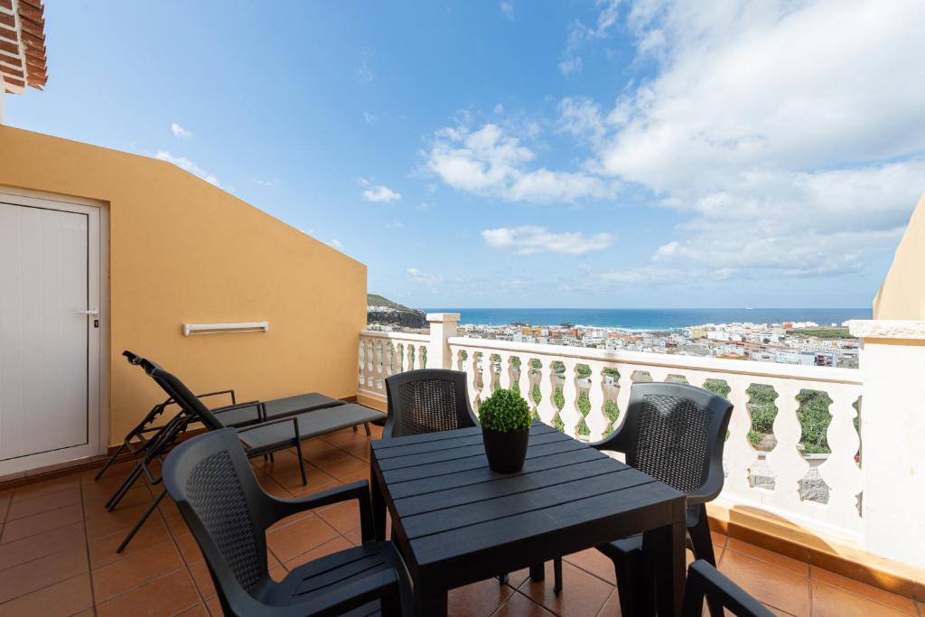 Un balcón con mesas y sillas y vistas al océano. en Costa Verde - Nature Views Terrace - Parking, en Trapiche