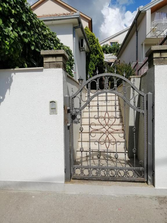 an entrance gate to a house with a white fence at Apartmants Mazoljice in Mostar