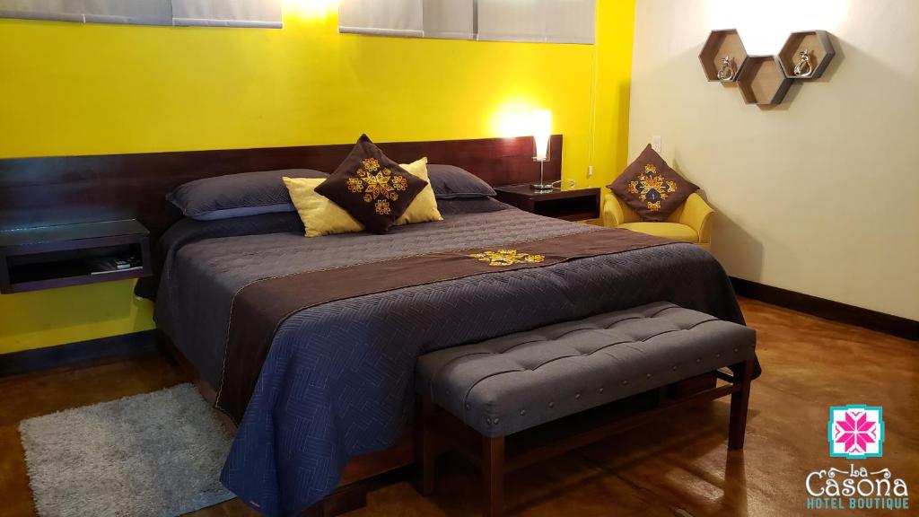 um quarto com uma cama grande e uma parede amarela em Hotel Boutique La Casona em Axtla