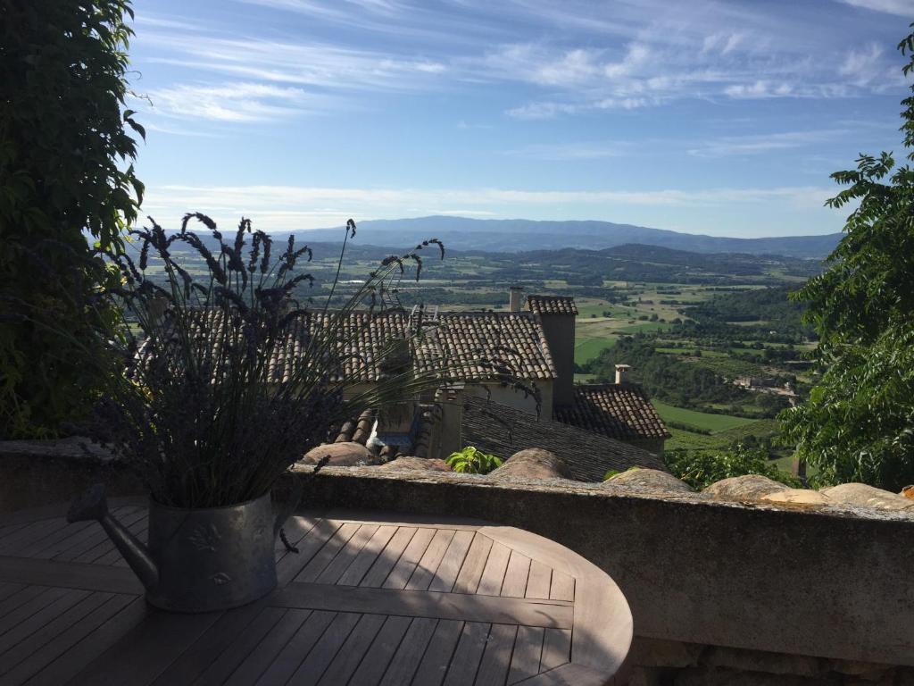 Chez Marius Gordes Vue panoramique sur luberon في جورد: شرفة مع نباتات الفخار وإطلالة