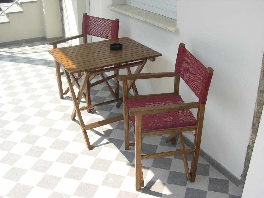 a wooden table and two chairs sitting next to a wall at Hotel Bristol in Tirrenia