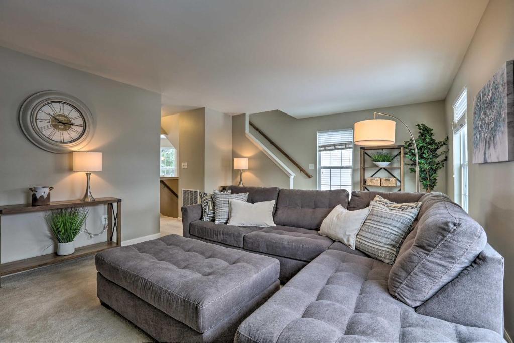 a living room with a gray couch and a large couch at Bellefonte Townhouse - 9 Miles to Penn State! in Bellefonte