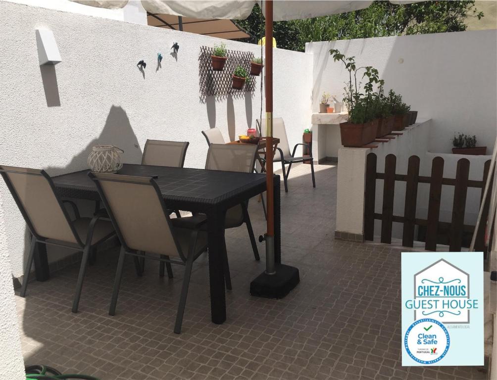 einen schwarzen Tisch und Stühle auf einer Terrasse in der Unterkunft Chez Nous - Guest House in Barreiro