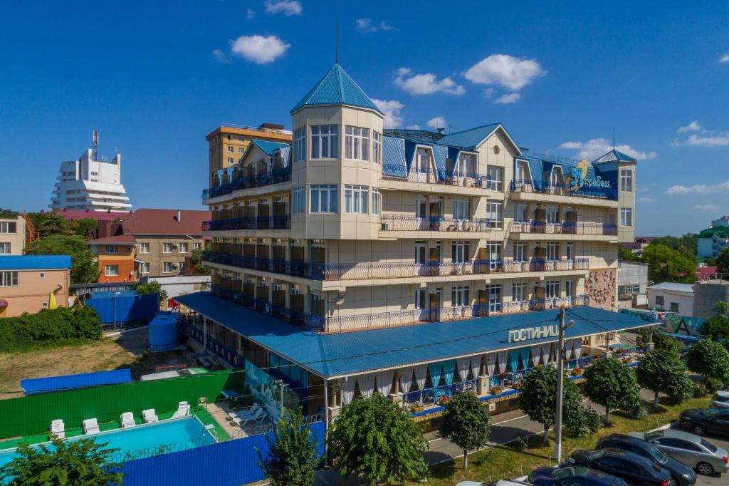un edificio de hotel con techo azul y aparcamiento en Mirabel Hotel, en Anapa