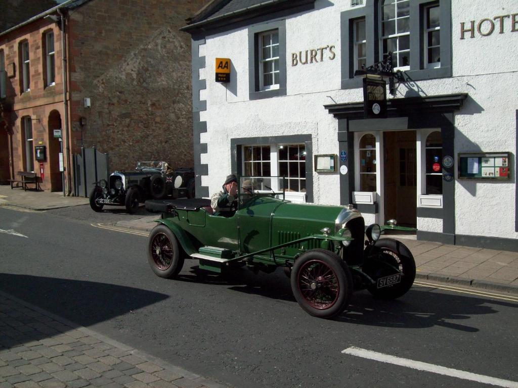 an old green car parked on the side of a street at Burt's Hotel in Melrose