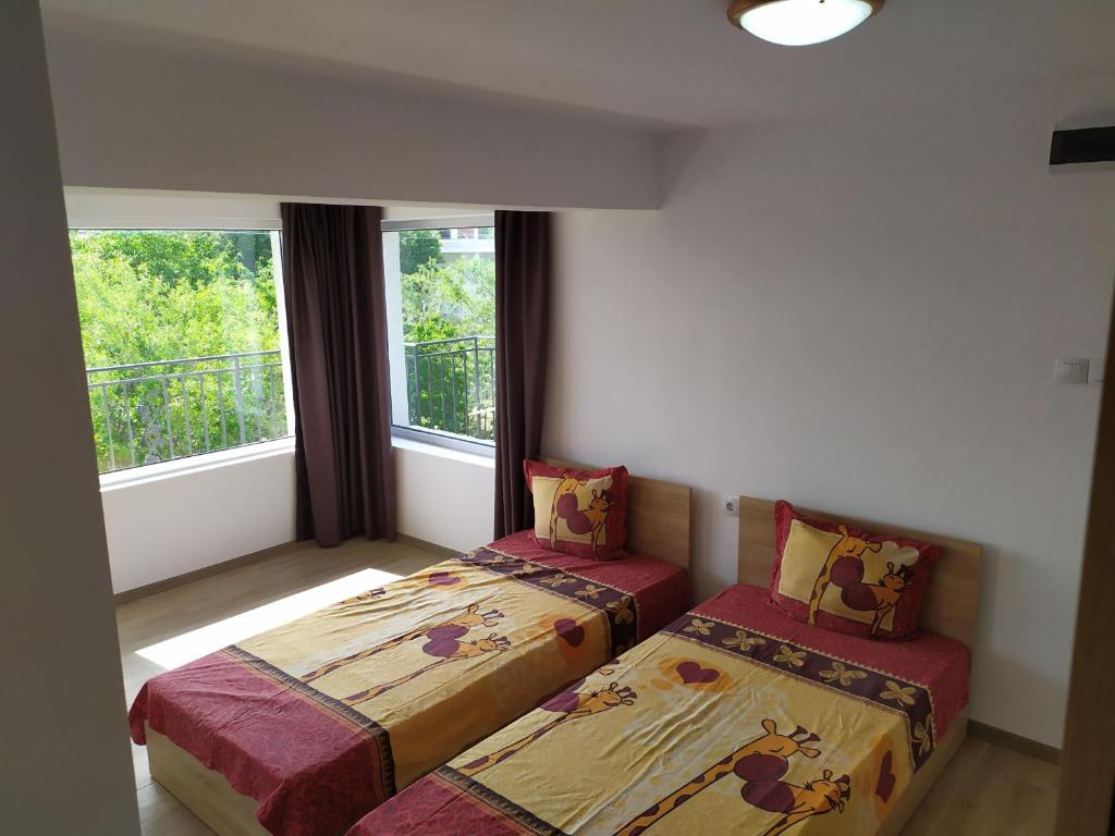 twee bedden in een kamer met twee ramen bij Villa Savovi in Varna
