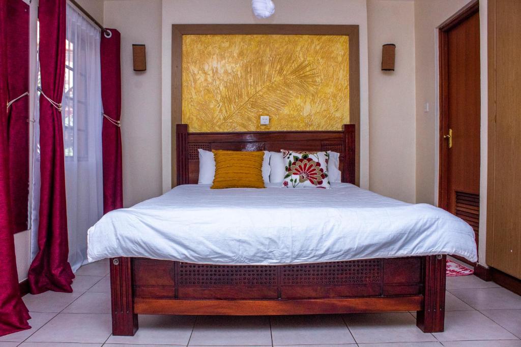 a bedroom with a large bed with yellow pillows at Kasty B Studios and Apartments in Nairobi