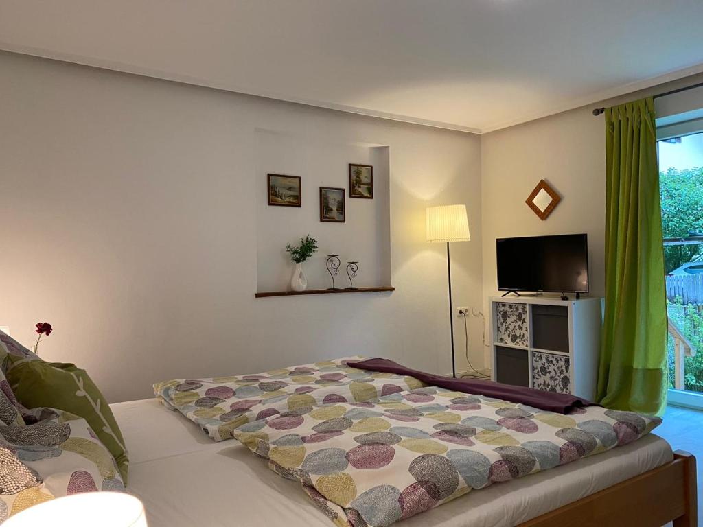 una camera da letto con un letto e una TV a schermo piatto di Alpen Apartement a Hallstatt