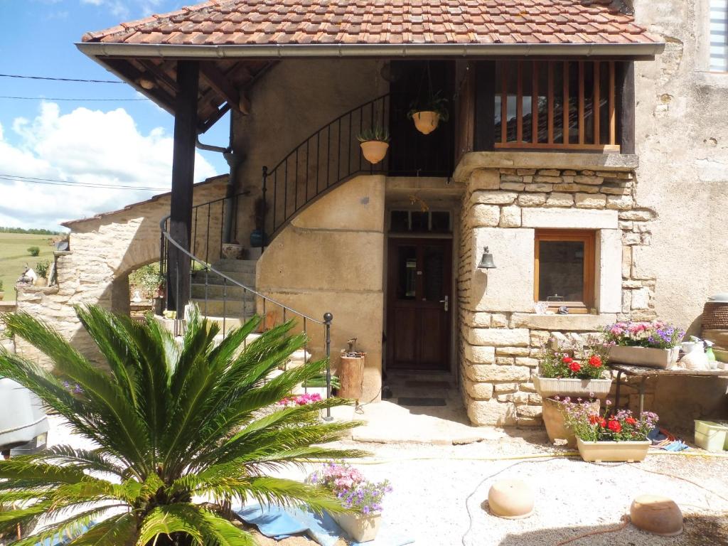 une maison en pierre avec une porte et une terrasse couverte dans l'établissement Chambre d'hôtes des 3 ifs, à Vernot