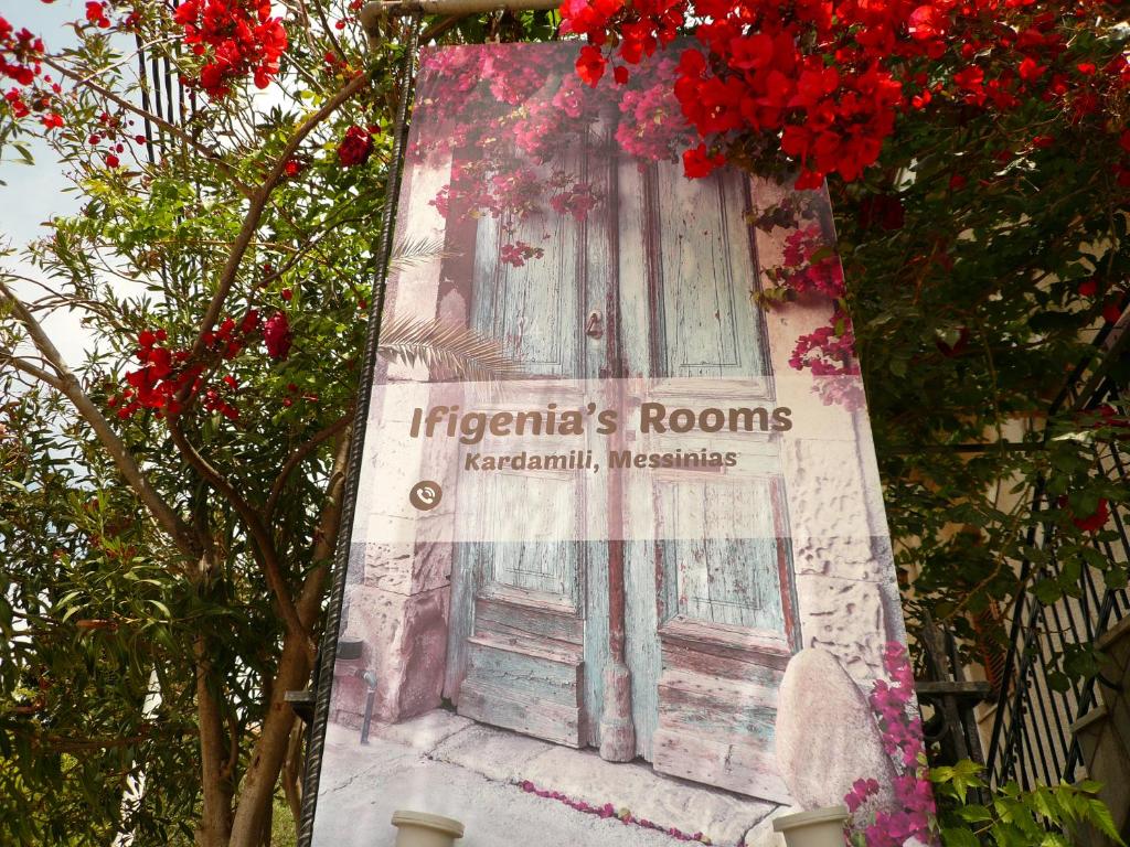 a sign on the side of a building with flowers at Ifigenia's Rooms in Kardamili