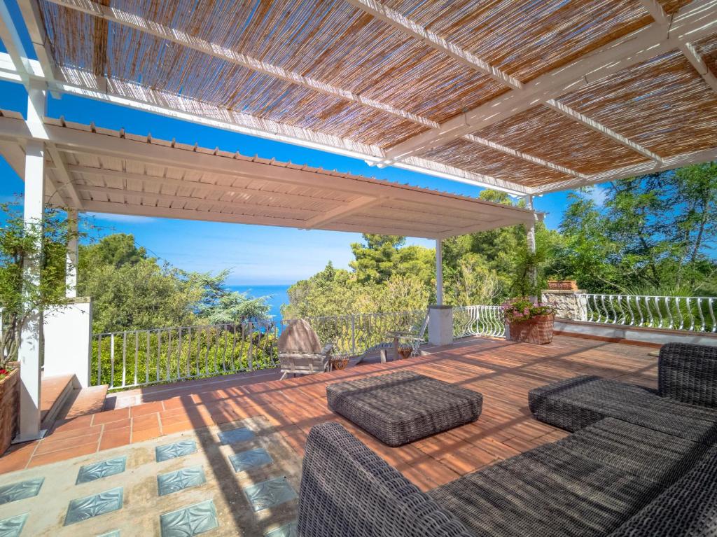una terraza al aire libre con pérgola y sillas en Bellavita BB, en Anacapri