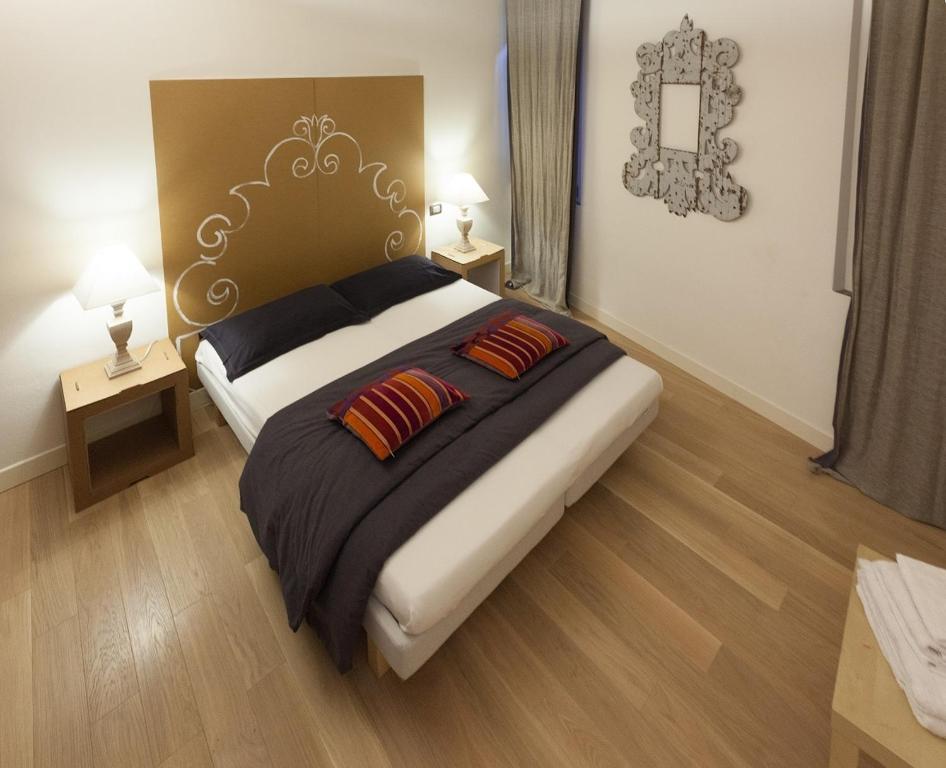 a bedroom with a large bed with two pillows at Parmigianino Nove in Parma