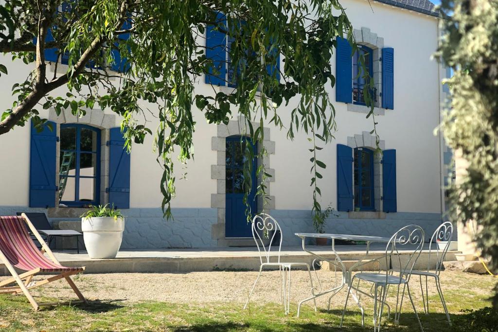 a group of chairs and tables in front of a building at Le clos de Lisa in Clohars-Carnoët