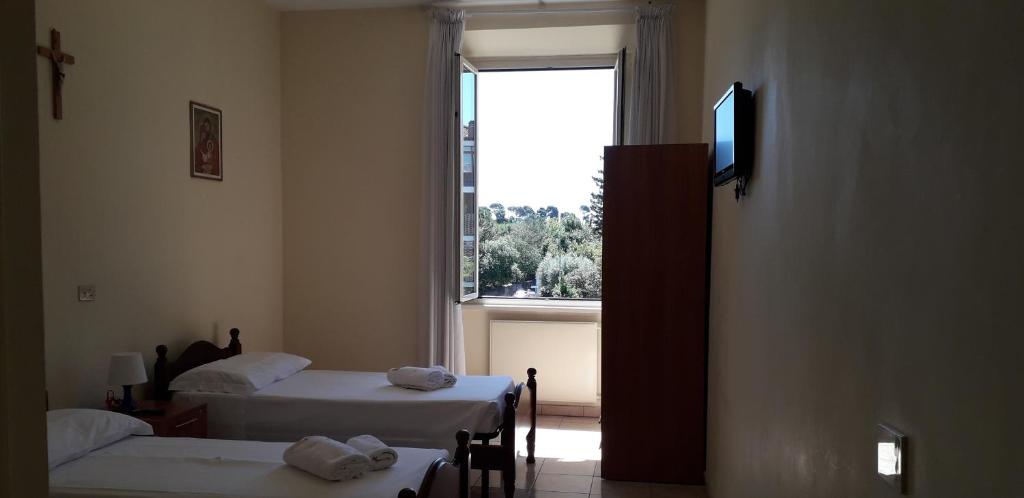 a room with two beds and a window at Ostello Villa Monte Mario in Rome