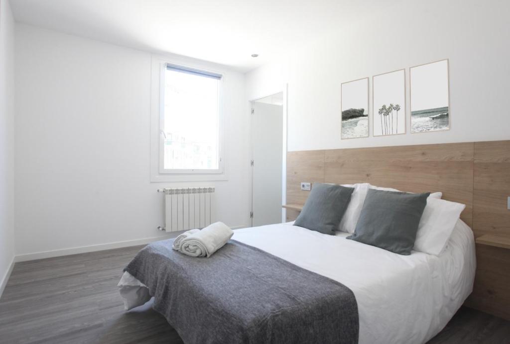 a bedroom with a large white bed with a wooden headboard at PATOS BEACH HOUSE in Nigrán