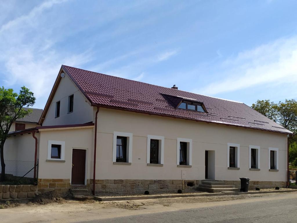 een wit huis met een rood dak bij Penzion Drnovec in Cvikov