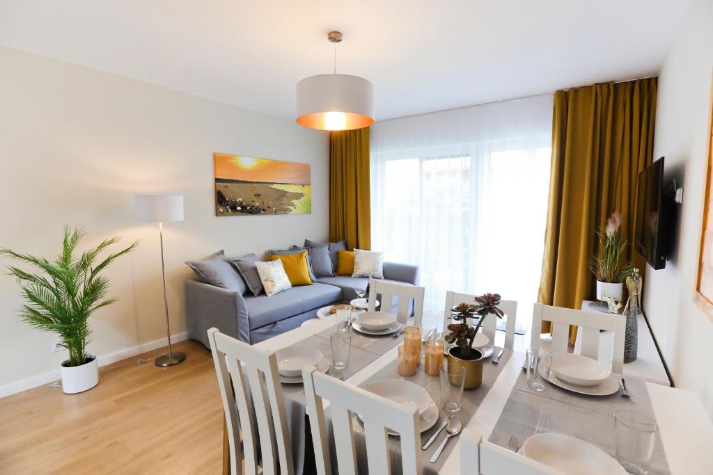 Un comedor y una sala de estar con mesa y sillas. en M&K Apartament Moc Natury Sobieszewo - Wyspa Sobieszewska, en Gdansk