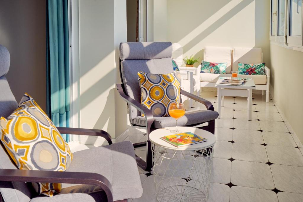 ein Wohnzimmer mit 2 Stühlen und einem Tisch in der Unterkunft Apartamento Málaga City Center in Málaga