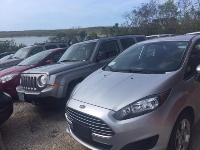 una fila di auto parcheggiate in un parcheggio di Harbor Breeze Villas a Clarence Town