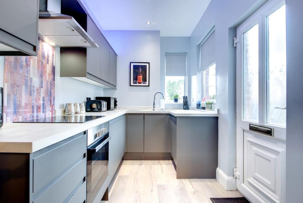 a kitchen with white counters and a sink at Modern Comfort-Family-friendly-Near City & Peaks in Sheffield