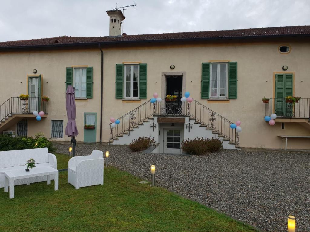 een huis met een binnenplaats met een gazon en stoelen bij Villa L' Antico Torchio in Dormelletto