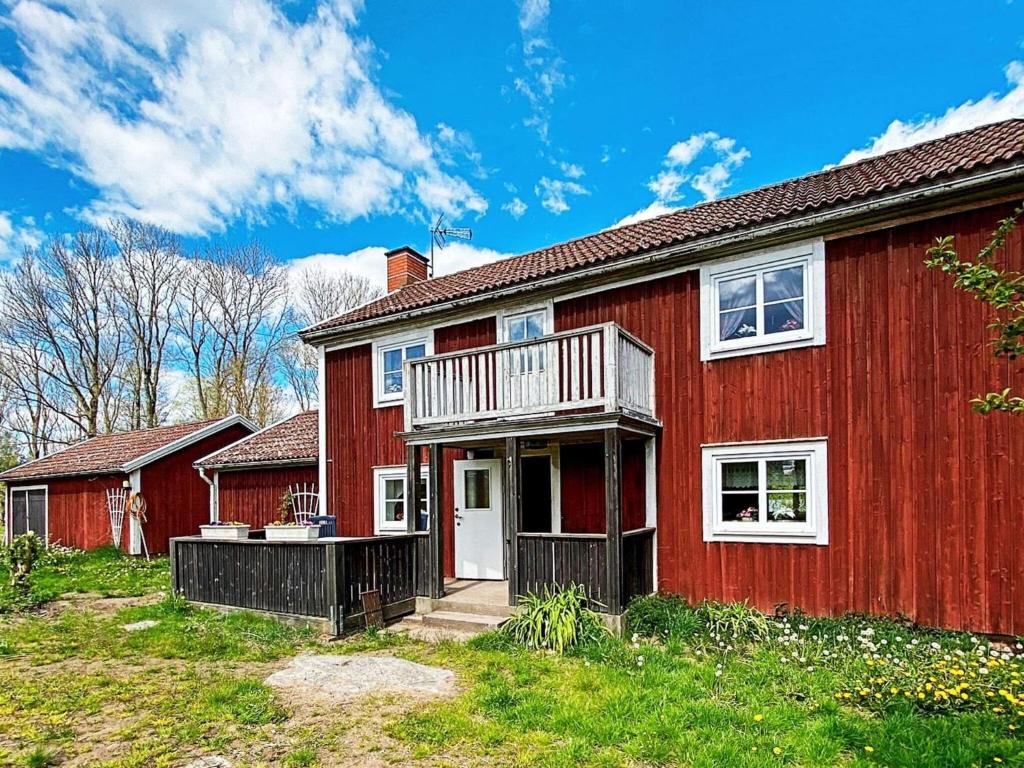 a red house with a balcony on it at 7 person holiday home in LMEDBODA in Älmeboda