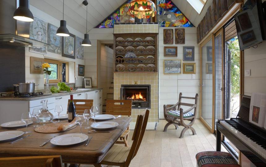 een eetkamer met een tafel en een open haard bij Mousterlin Cottage in Fouesnant