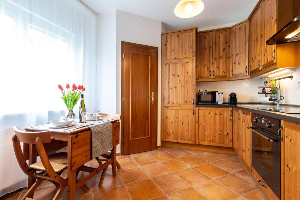 eine Küche mit Holzschränken sowie einem Tisch und Stühlen in der Unterkunft Apartmán Dream v Mikulově - Jiné ubytování Lednice in Mikulov
