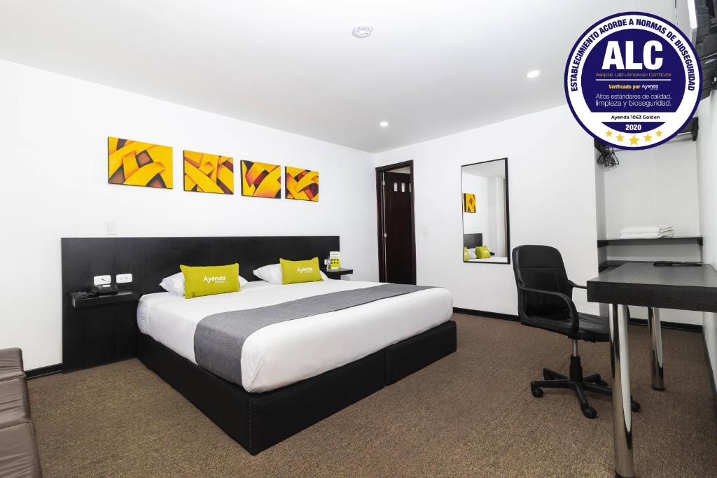 波哥大的住宿－Ayenda 1063 Golden，酒店客房配有一张床、一张书桌和一张书桌。