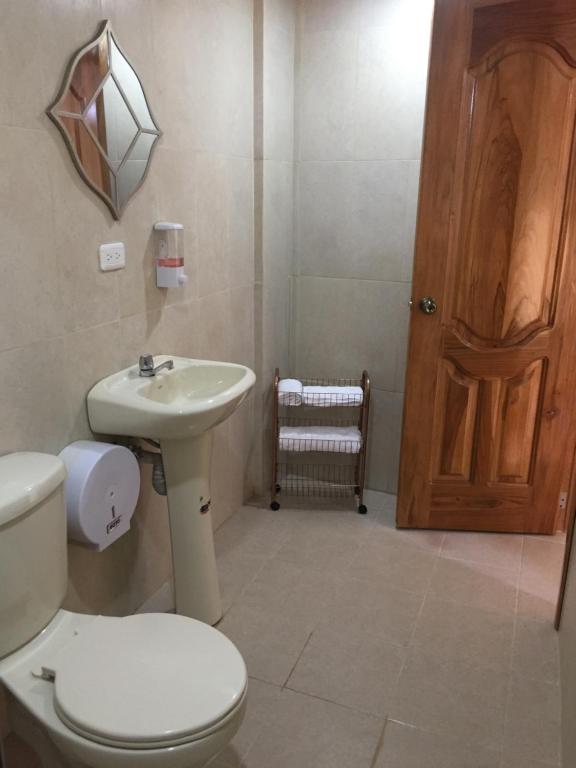 a bathroom with a white toilet and a sink at Tababela Airport B&B in Tababela