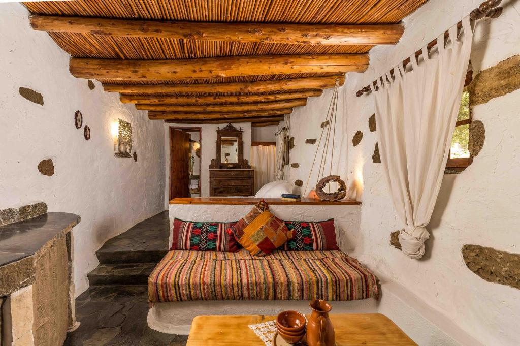 a living room with a couch and a table at Natura cottages in Makry Gialos