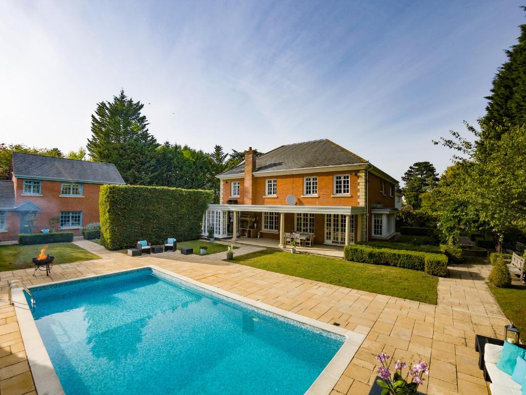a large swimming pool in front of a house at Gleneagles in Ascot