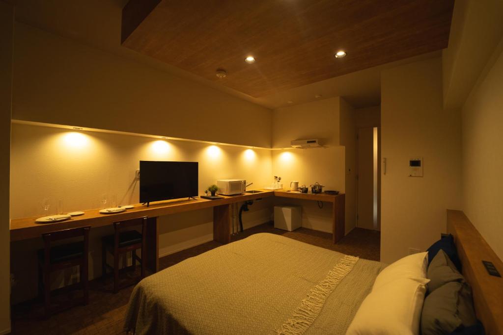 a bedroom with a bed and a desk with a computer at HIT Tenjin in Fukuoka