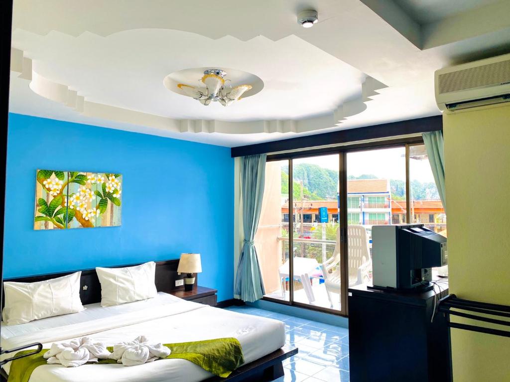 a blue bedroom with a bed and a tv at J Hotel in Ao Nang Beach