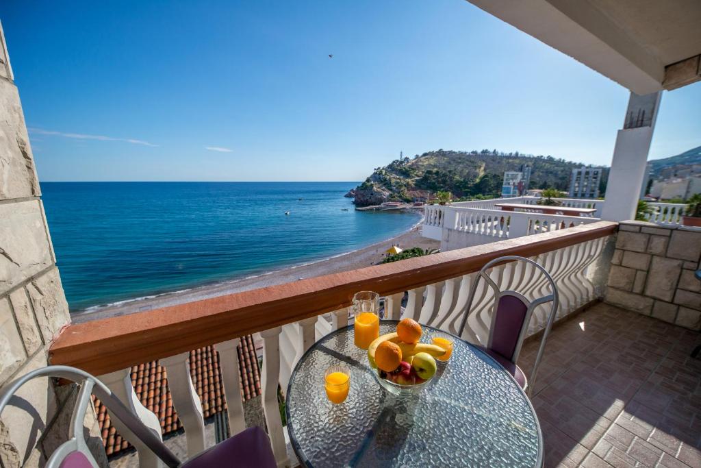 een tafel op een balkon met uitzicht op de oceaan bij Apartmani Stari Grad in Sutomore